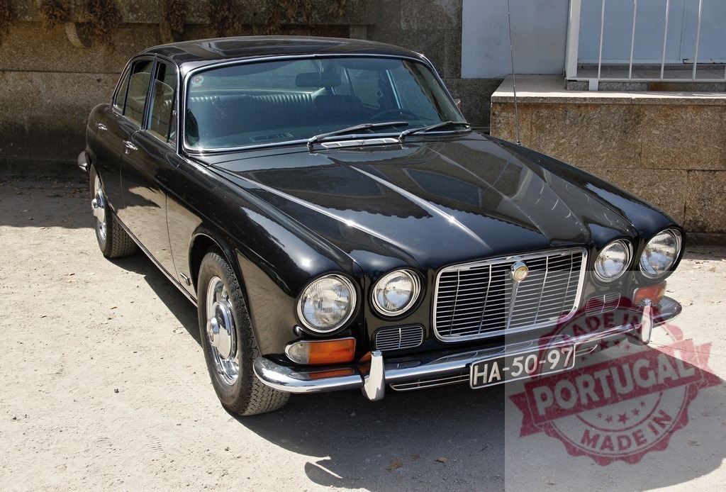 Black Jaguar XJ classic car parked in daylight | Black Jaguar XJ vintage sedan parked outdoors, reflecting sunlight on its sleek body - Realized with Pictrs.com