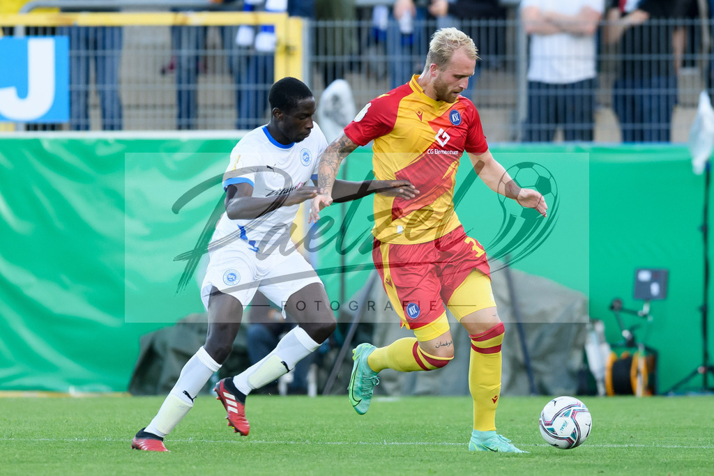 LOTKSC20210809_047 | Fussball, Herren: Komlan Fionouke (Sportfreunde Lotte) und Philipp Hofmann (Karlsruher SC) im Zweikampf beim Spiel der 1. Runde im DFB-Pokal zwischen SF Lotte und Karlsruher SC im Stadion am Lotter Kreuz am 09.08.2021 in Lotte, Deutschland.DFB / DFL REGULATIONS PROHIBIT ANY USE OF PHOTOGRAPHS AS IMAGE SEQUENCES AND/OR QUASI-VIDEO. - Realisiert mit Pictrs.com