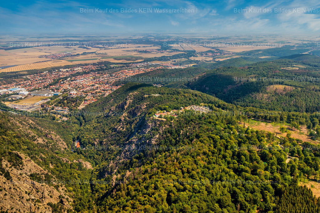 Harz bei Thale Roßtrappe-0053 | Das Luftbild von Thale zeigt eine atemberaubende Landschaft, in der der Hexentanzplatz majestätisch über dem Bodetal thront. Umgeben von dichten Wäldern und beeindruckenden Felsformationen bietet der Platz einen spektakulären Blick auf die malerische Umgebung. Die sanften Kurven des Bodetals schlängeln sich durch die Natur und verleihen der Szenerie eine besondere Ruhe und Schönheit. In der Ferne sind die charakteristischen Gebäude von Thale zu erkennen, die die charmante Atmosphäre des Ortes unterstreichen. Dieses Bild fängt die magische Verbindung zwischen Natur und Mythos ein, die Thale so einzigartig macht. - Realisiert mit Pictrs.com