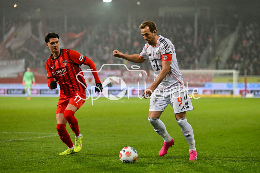 1. FC Heidenheim - FC Bayern München | HEIDENHEIM, GERMANY - 21. DECEMBER: im Duell Mathias HONSAK (1. FC Heidenheim 17) und Harry KANE (FC Bayern Munich 9) während dem Bundesligamatch zwischen dem 1. FC Heidenheim und dem FC Bayern München am 15. Spieltag in der Voith-Arena / DFL REGULATIONS PROHIBIT ANY USE OF PHOTOGRAPHS AS IMAGE SEQUENCES AND/OR QUASI-VIDEO