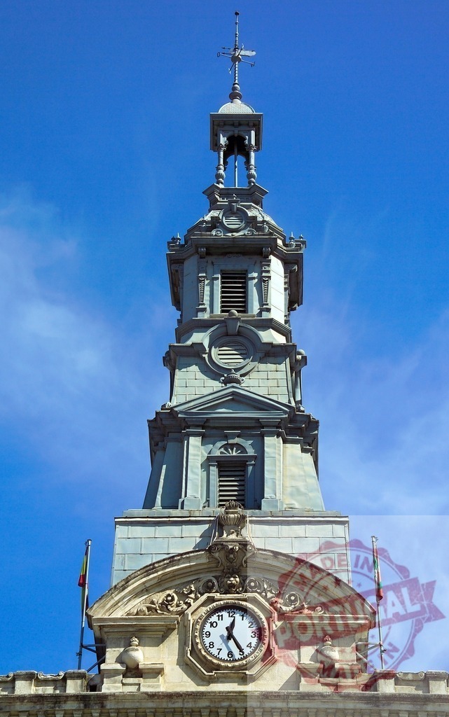 Bilbao City Council clock tower architectural detail. Spain - Bilbao | Bilbao City Council building featuring clock tower and spire against a blue sky - Realized with Pictrs.com