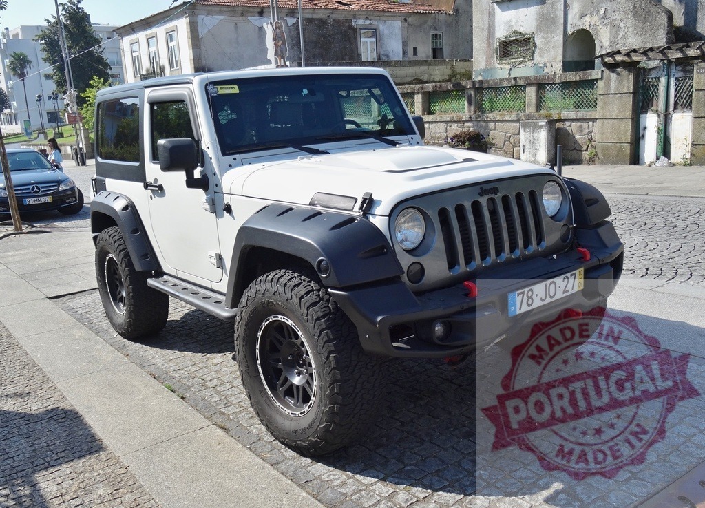 White Jeep Wrangler 4x4 off-road vehicle parked on street | White Jeep Wrangler off-road vehicle parked on a sunny paved street in a town setting - Realized with Pictrs.com