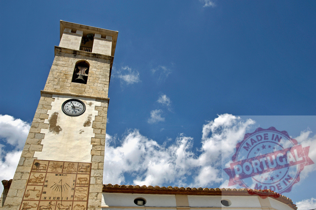 Historic clock tower with sundial and zodiac signs under blue sky | Stone bell tower featuring clock, sundial, and zodiac signs against a blue sky - Realized with Pictrs.com