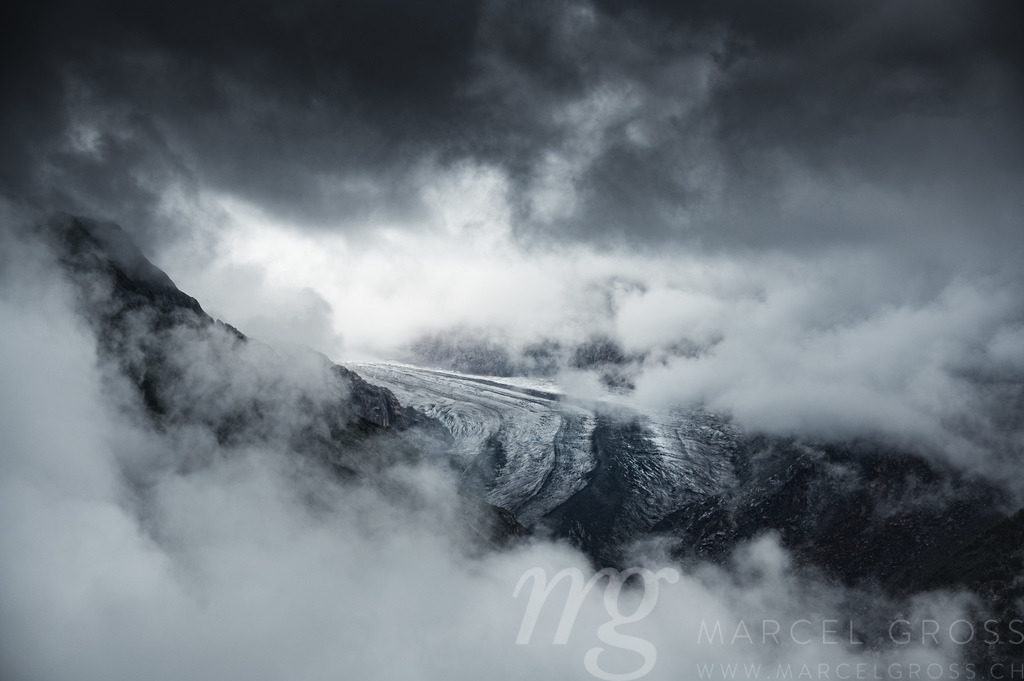 moody and dark  scenery on Aletsch Glacier an a cloudy and rainy day | Die ideale Geschenkidee für Naturliebhaber. Naturbilder von Marcel Gross Photography für ihr Zuhause in den verschiedensten Formaten und Materialien. - Realisiert mit Pictrs.com
