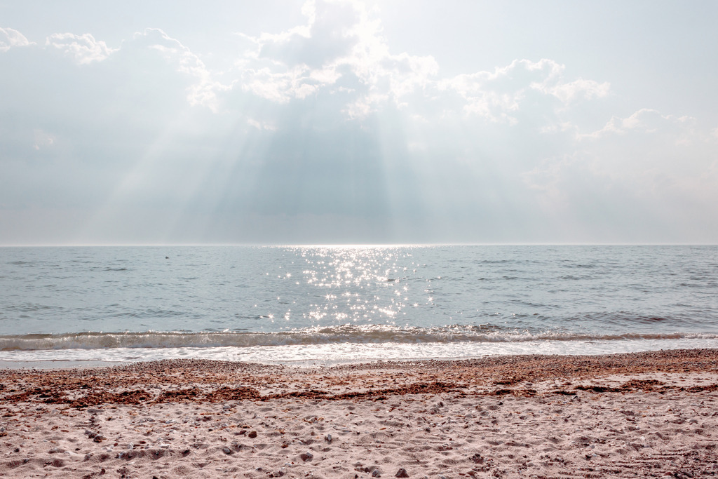 Wandbild: Sonnenschein am Sandstrand | Dieses Wandbild im Querformat zeigt eine schöne Lichtstimmung am Meer. Das Licht der Sonne scheint in schönen Sonnenstrahlen durch die Wolken aufs Meer. Im Vordergrund ist der Sandstrand zu sehen auf dem rotbrauner Seetang liegt. Sie lieben maritime Deko? Dann passt dieses Wandbild perfekt zu Ihnen. Verschönern Sie Ihr Zuhause im Wohnzimmer, Schlafzimmer und Küche. Oder schaffen Sie ein tolles Urlaubsflair in Ihrer Ferienwohnung. Dieses Wandbild ist auf Leinwand, Alu-Dibond, Acrylglas oder als Holzdruck erhältlich. Die Wandbilder werden individuell für Sie in vielen Abmessungen produziert. Daher passen die Ostseekult Wandbilder immer perfekt an Ihre Wände. - Realisiert mit Pictrs.com