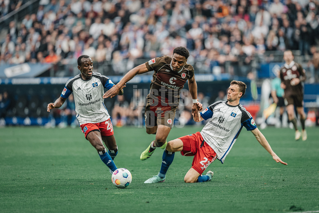 Fußball | Männer | Saison 2023/2024 | 2. Fußball-Bundesliga | 32. Spieltag | Hamburger SV vs. FC St. Pauli  | 03.05.2024 | Oladapo Afolayan (#17, FC St. Pauli) kämpft sich durch die Mitte von Jean-Luc Dompe (#27, HSV) und Jonas Meffert (#23, HSV)