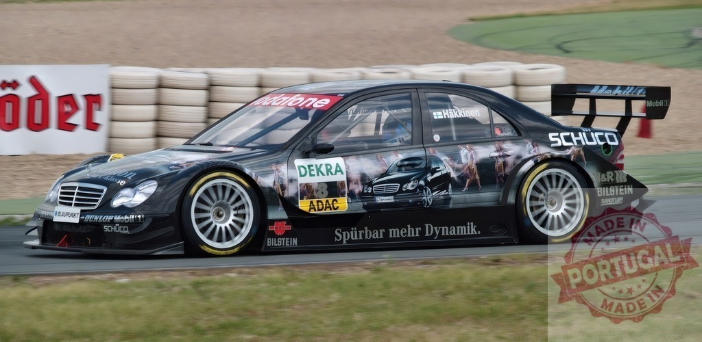 Mercedes-Benz DTM race car speeding on racetrack | Mercedes-Benz DTM race car number 8 with Mika Häkkinen branding racing during an event - Realisiert mit Pictrs.com