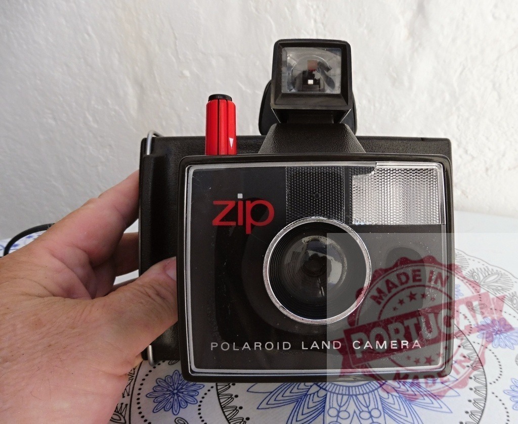 Hand holding vintage Polaroid Land Camera Zip instant film | Hand holding a classic Polaroid Land Camera Zip, representing nostalgia and retro photography - Realized with Pictrs.com