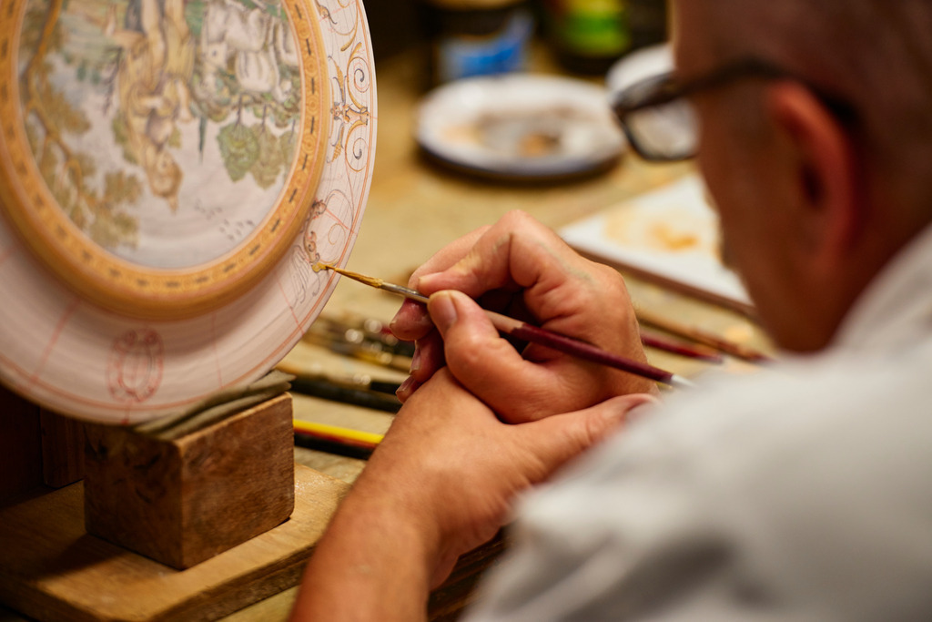 Maestro Caravaggi bemalt den Teller | Deruta, Italien - August 31, 2016: Keramikmanufaktur Torretti; Maestro Caravaggi bemalt einen Teller. - Realisiert mit Pictrs.com