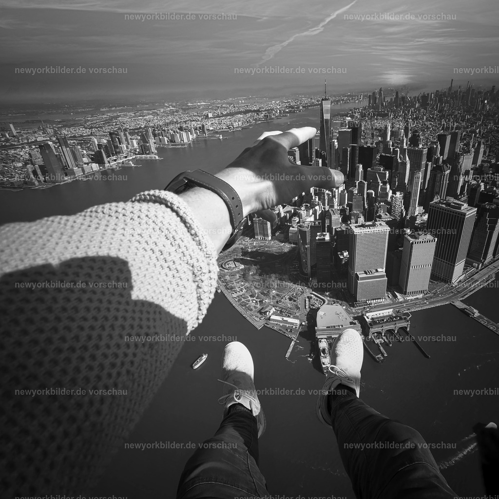 Freiheit über Manhattan – Das One World Trade Center zum Greifen nah | Das One World Trade Center so nah, als könnte man es berühren – eingefangen aus einem offenen Helikopter über Manhattan. Die Beine hängen frei in der Luft, der Wind streicht über das Gesicht, und die Skyline breitet sich unter einem aus wie ein endloses Meer aus Licht und Architektur. Dieses Foto zeigt eine Perspektive, die nur wenige erleben: die Spitzen der Wolkenkratzer aus nächster Nähe, die Energie der Stadt aus der Vogelperspektive und das Gefühl grenzenloser Freiheit. Es ist ein immersives Abenteuer, das die Liebe zur Skyline und die Faszination für New York in einem einzigen Moment vereint. Wer dieses Bild betrachtet, spürt den Nervenkitzel und die Magie, die entsteht, wenn man die Metropole aus einer Perspektive sieht, die alles andere vergessen lässt – außer dem Traum, über Manhattan zu fliegen.