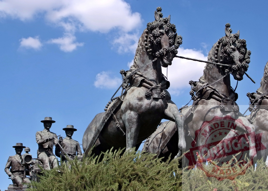Monumento a los Caballos sculpture with driving men in Vigo. Espana - Cadiz | Monumento a los Caballos bronze sculpture depicting horses and men under blue sky - Realized with Pictrs.com