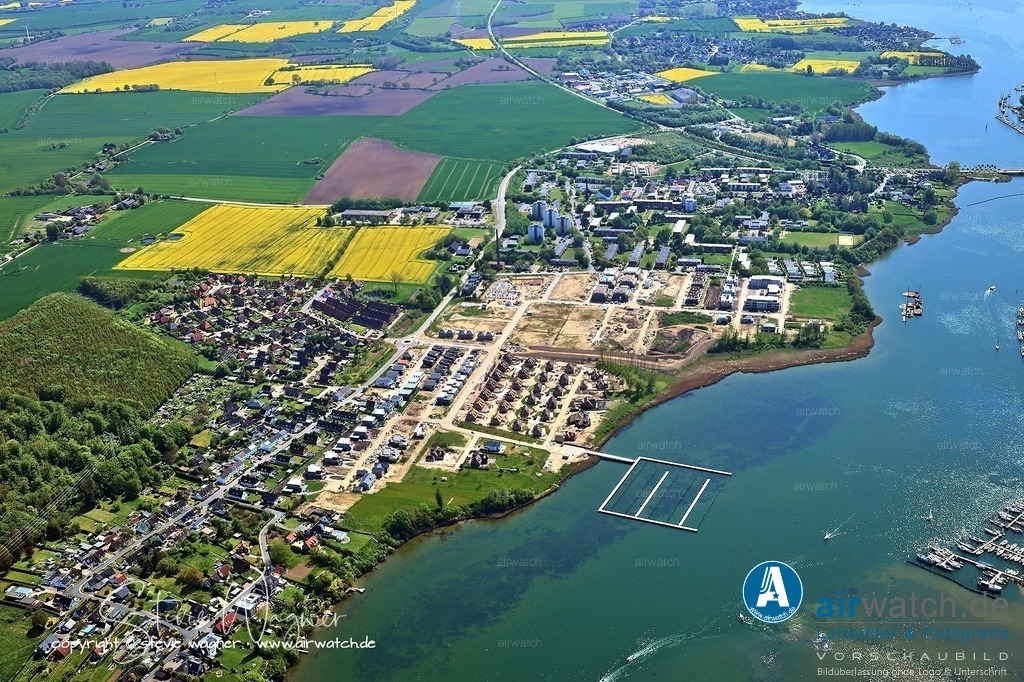 Luftbild Kappeln an der Schlei - Die Schleiterrassen in Kappeln-Ellenberg | Die Schleiterrassen in Kappeln-Ellenberg sind ein großes Neubauvorhaben auf dem Gelände der ehemaligen Marinewaffenschule direkt an der Schlei. Das Projekt umfasst Einfamilienhäuser, Doppelhäuser und Mehrfamilienhäuser mit hochwertiger Ausstattung und teilweise direktem Wasserblick. Die Lage kombiniert Naturverbundenheit mit moderner Infrastruktur, wodurch das Quartier besonders attraktiv für Eigennutzer und Kapitalanleger ist.
