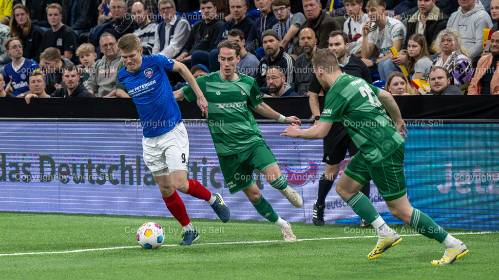 SHFV Lotto Masters 2024 | 20240113_7798, 13.01.2024, SHFV Lotto Masters 2024, Gruppe B, TSB Flensburg (blau) vs. PSV Neumünster (grün), Nicholas Holtze (TSB #9) / Jesper Tiedemann (PSV #11) &amp; Timo Barendt (PSV #22) - Realisiert mit Pictrs.com