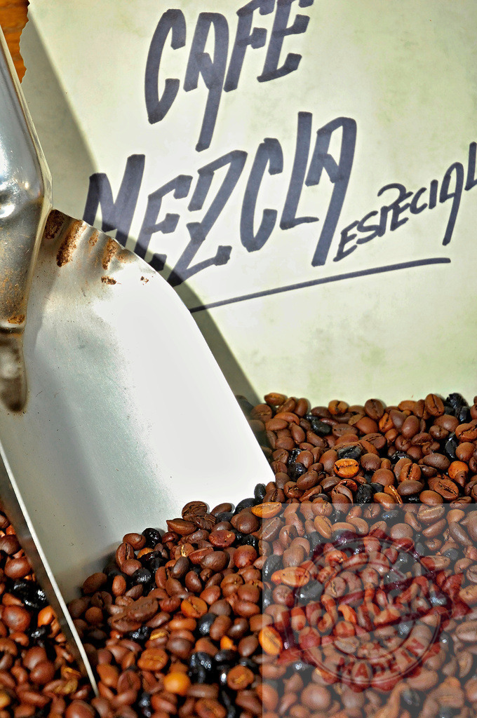 Roasted coffee beans scoop with Cafe Mezcla Especial sign | Roasted coffee beans with a rustic metal scoop and a sign for special blend coffee - Realized with Pictrs.com