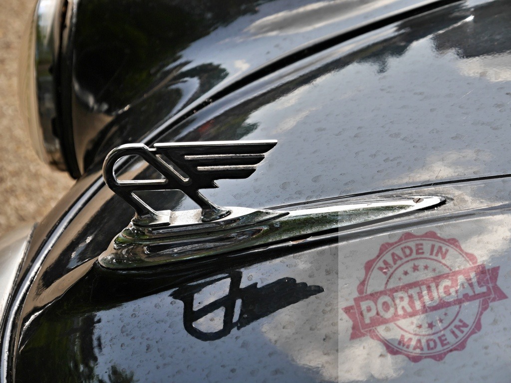 Classic vintage car hood ornament chrome detail | Chrome hood ornament adorning a classic black car with reflections - Realized with Pictrs.com