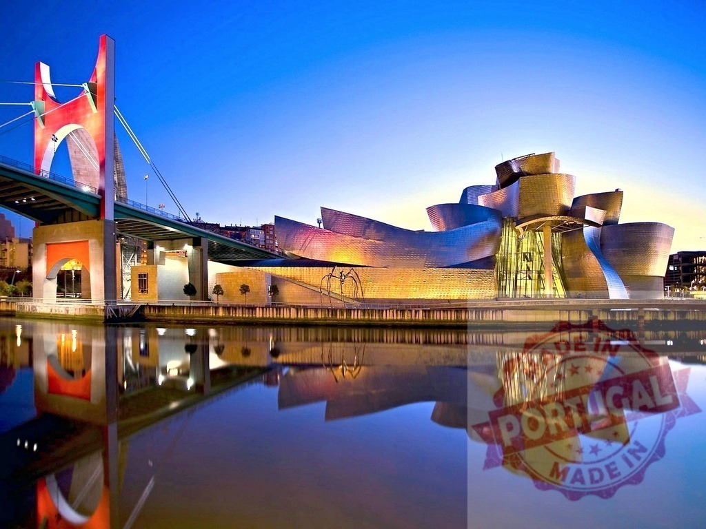 Guggenheim Museum Bilbao and La Salve Bridge reflecting at dusk. Spain - Bilbao | Guggenheim Museum Bilbao and La Salve Bridge standing along river with reflections at twilight - Realized with Pictrs.com