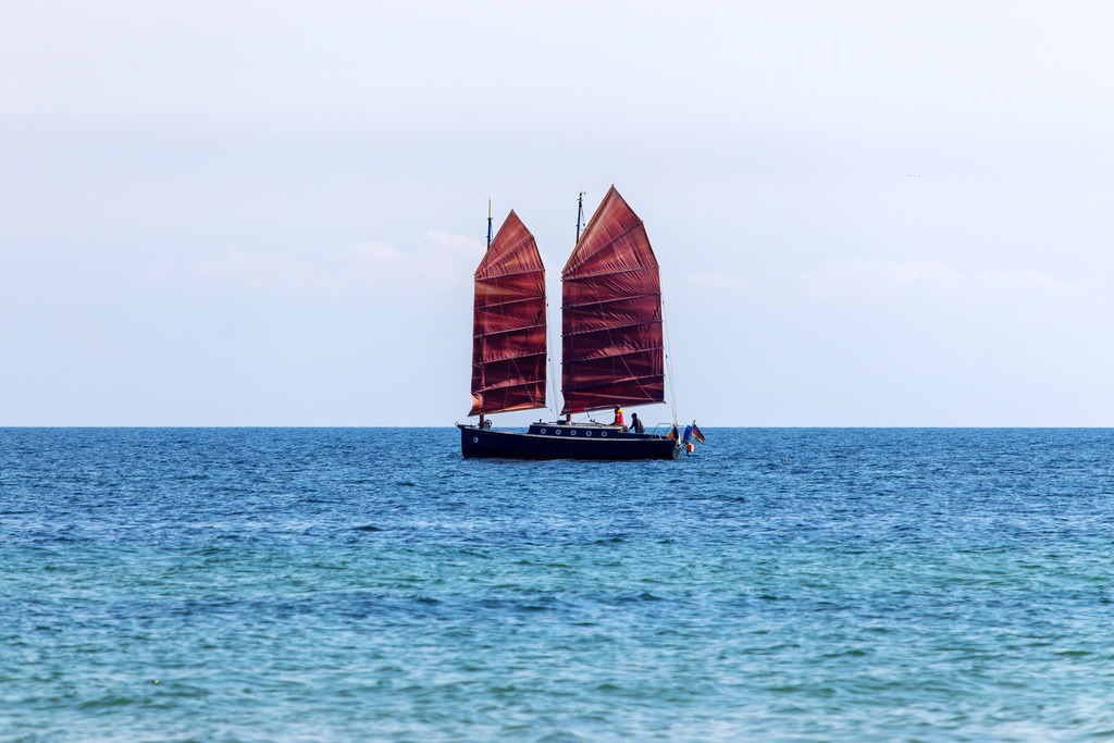 Wandbild: Weite und Wind – Ein Boot auf ruhiger See | Die beruhigende Weite der Ostsee eingefangen in einem harmonischen Motiv – dieses Wandbild zeigt ein Segelboot vor dem Weidefelder Strand. Die sanften Farben und die ruhige Wasseroberfläche schaffen eine entspannte und wohltuende Bildwirkung. - Realisiert mit Pictrs.com