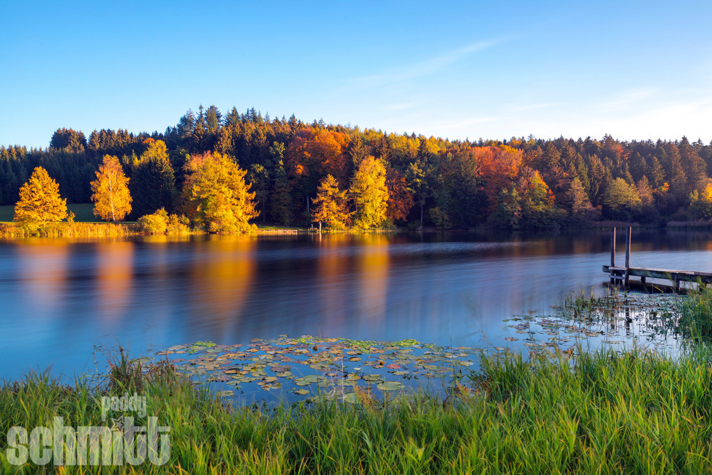 Steg bei Karsee im Herbst | Ein idyllischer Steg am Karsee, umgeben von warmen Herbstfarben und der stillen Schönheit der Natur. - Realisiert mit Pictrs.com