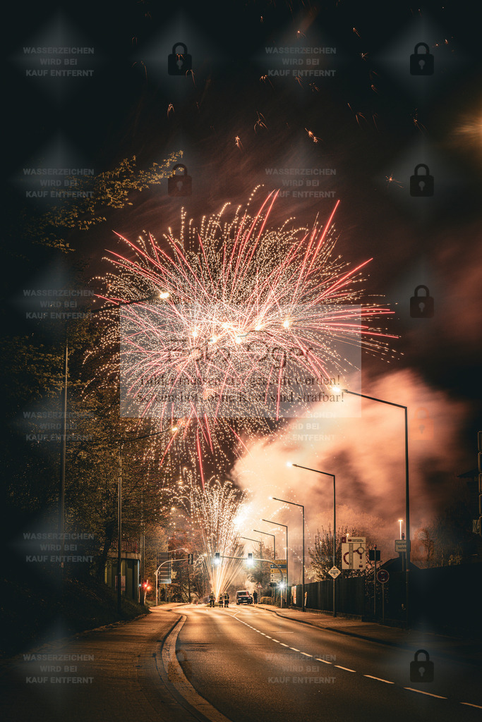 Feuerwerk über der nächtlichen Straße | Ein leuchtendes Feuerwerk erhellt die nächtliche Straße und taucht die Szene in warme Farben. Die Kombination aus urbaner Kulisse, aufsteigendem Rauch und funkelnden Explosionen schafft eine besondere Atmosphäre zwischen Ruhe und Energie. Ein Moment, in dem die Nacht für einen Augenblick zum Tag wird. - Realisiert mit Pictrs.com