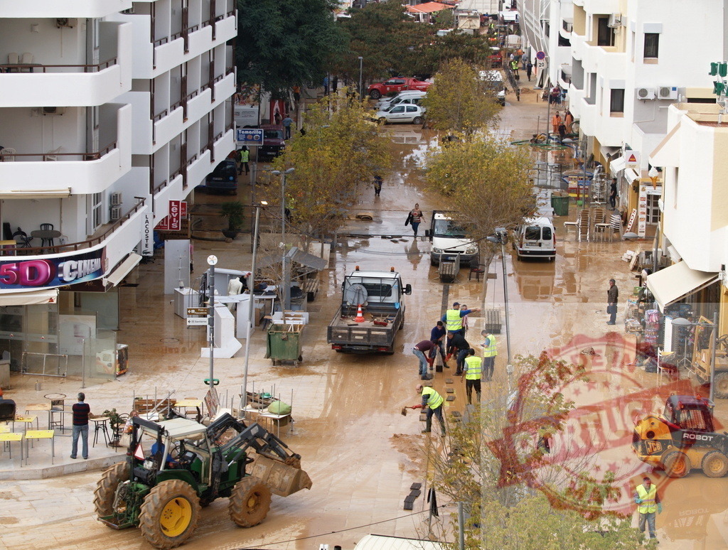 Street cleanup after flood disaster in city | Albufeira Flood - discruction by weather problems Workers and heavy equipment cleaning a street after a natural disaster flood - Realisiert mit Pictrs.com