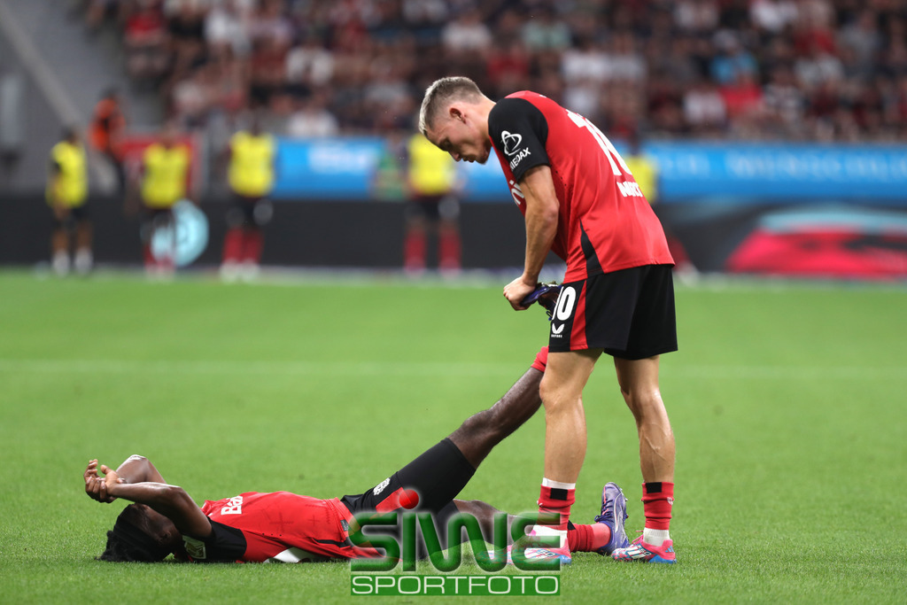 1.Fussball-Bundesliga  :    Bayer 04 Leverkusen--RB Leipzig   2.Spltg. | 31.08.2024.2024; Fussball; GER;  Saison 2024/2025 ; 1.Bundesliga;  2.Spieltag. :  Bayer 04 Leverkusen-- RB Leipzig  :     Florian Wirtz (10/B04)  hilft  Jeremie Frimpong (30/B04), der Krämpfe hat.DFL REGULATIONS PROHIBIT ANY USE OF PHOTOGRAPHS AS IMAGE SEQENCES AND/OR QUASI-VIDEO. - Realisiert mit Pictrs.com