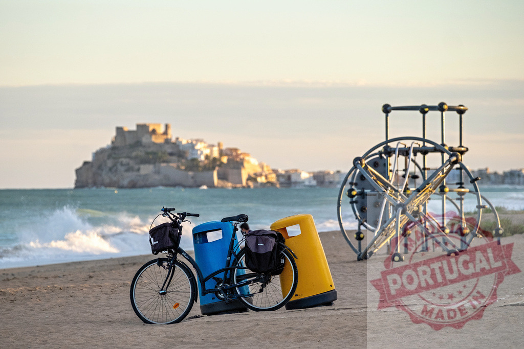 Bicycle parked on beach with Peñíscola castle background | Bicycle parked between trash cans on a sandy beach with Peñíscola castle and sea in background - Realisiert mit Pictrs.com