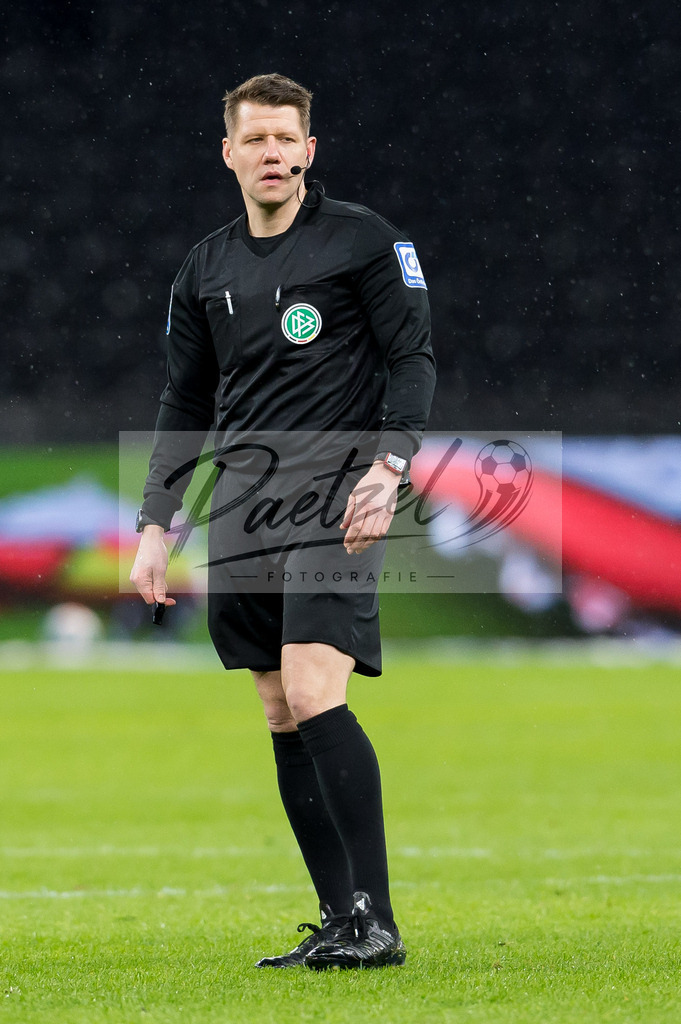 BSCRBL20220220_031 | Fussball, Herren: Schiedsrichter Patrick Ittrich schaut bei dem Spiel der 1. Bundesliga zwischen Hertha BSC und RB Leipzig im Olypiastadion am 20.02.2022 in Berlin, Deutschland.DFB / DFL REGULATIONS PROHIBIT ANY USE OF PHOTOGRAPHS AS IMAGE SEQUENCES AND/OR QUASI-VIDEO. - Realisiert mit Pictrs.com