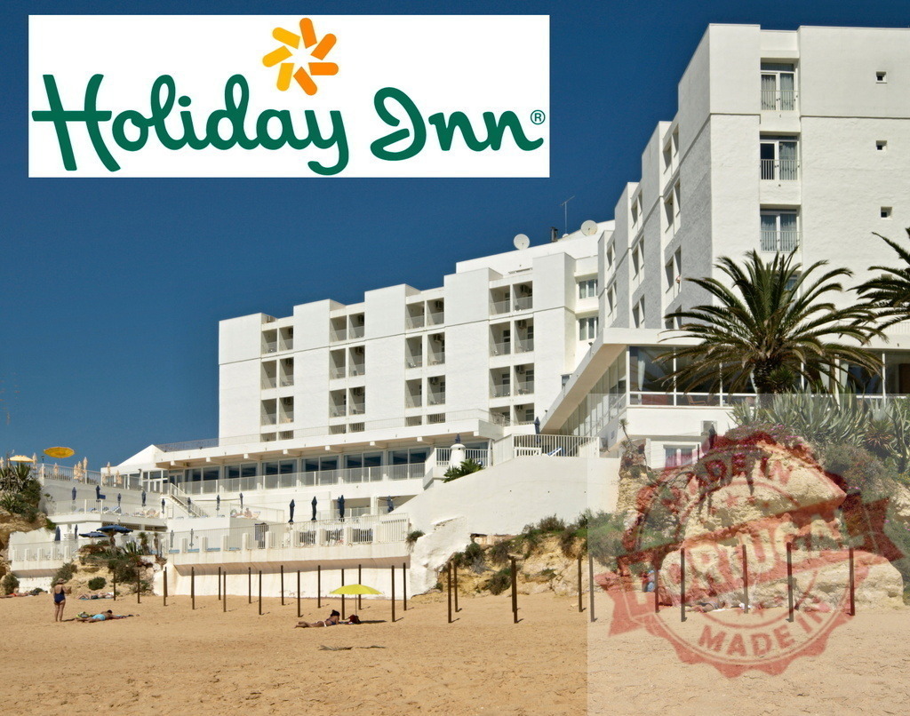Holiday Inn hotel building on sunny beach | Holiday Inn resort building overlooking a sandy beach with people relaxing under sun umbrellas - Realized with Pictrs.com