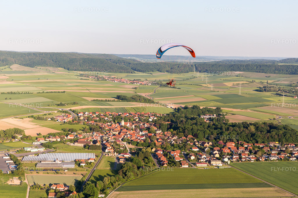 Luftbild: Paragleiter über einem Dorf am Rande von landwirtschaftlichen Feldern und Nutzflächen in Rüdenhausen im Bundesland Bayern in Deutschland. Foto: IMG_100378.jpg vom 27.05.2017 durch Werner Riehm/FLY-FOTO.de