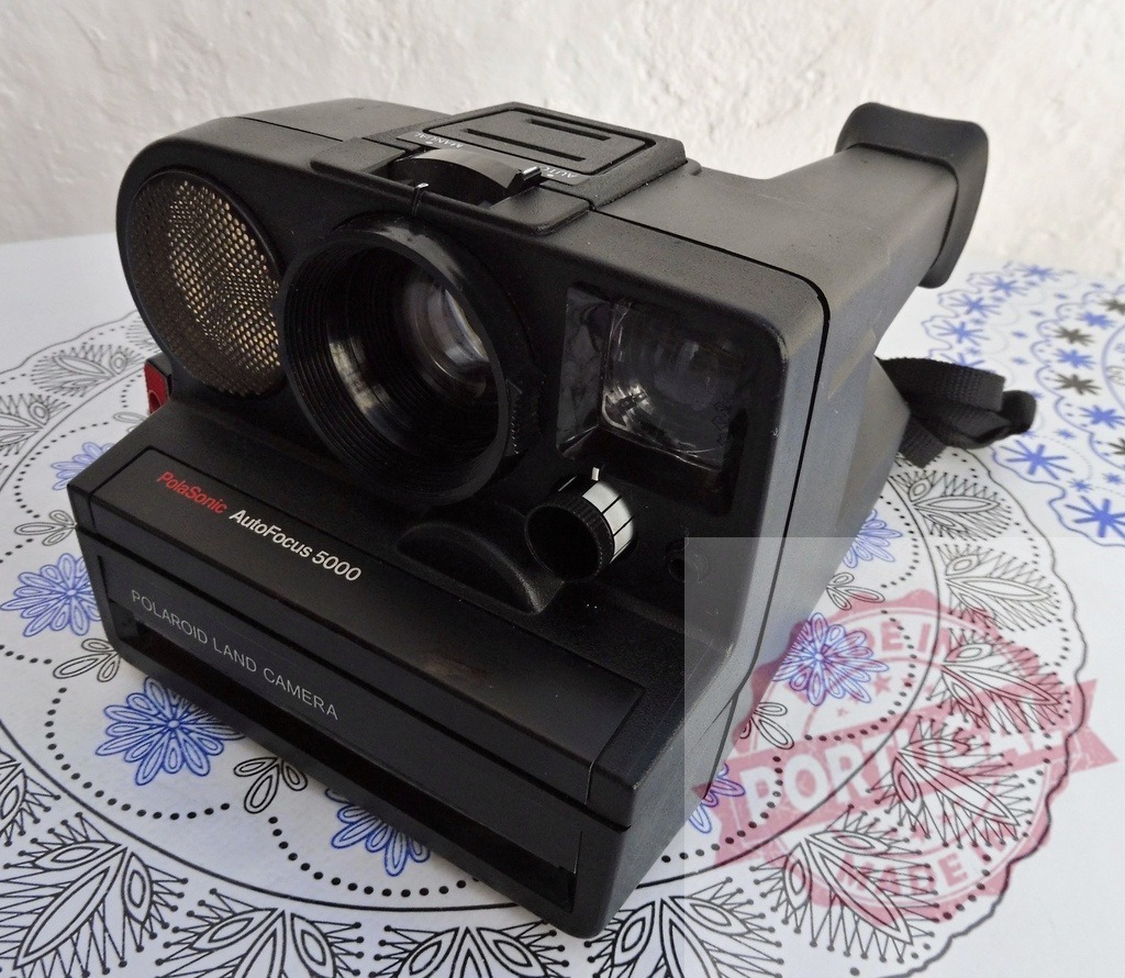 Polaroid PolaSonic AutoFocus 5000 instant camera representing vintage photography | Polaroid PolaSonic AutoFocus 5000 instant camera on table capturing retro photography concept - Realisiert mit Pictrs.com