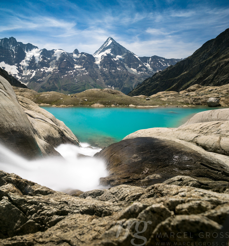 Mountain Stream above emerald blue Blauseeli | Captured while hiking with a friend in Lötschental, Valais. In the Background you can see the northside of Bietschhorn. The effect is created by a ND-Filter to take a longexposure-picture during bright daylight. - Realisiert mit Pictrs.com