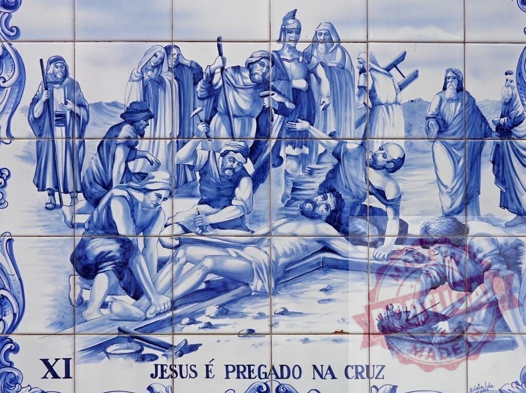 Jesus being nailed to the cross on azulejo tile | Jesus Christ's crucifixion portrayed on traditional blue and white azulejo ceramic tiles - Realisiert mit Pictrs.com