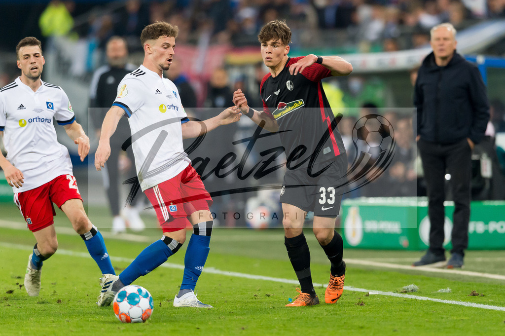 HSVSCF20220419_231 | Fussball, Herren: Moritz Heyer (Hamburger SV) und Noah Weisshaupt (SC Freiburg) im Zweikampf beim DFB-Pokal-Halbfinalspiel zwischen Hamburger SV und SC Freiburg im Volksparkstadion am 19.04.2022 in Hamburg, Deutschland.DFB / DFL REGULATIONS PROHIBIT ANY USE OF PHOTOGRAPHS AS IMAGE SEQUENCES AND/OR QUASI-VIDEO. - Realisiert mit Pictrs.com