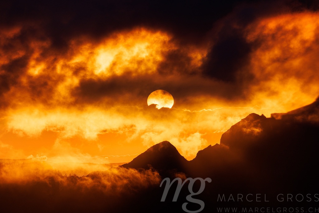 dramatic sunset with clouds and the sun in the Alpine foothills of Fribourg | Die ideale Geschenkidee für Naturliebhaber. Naturbilder von Marcel Gross Photography für ihr Zuhause in den verschiedensten Formaten und Materialien. - Realisiert mit Pictrs.com