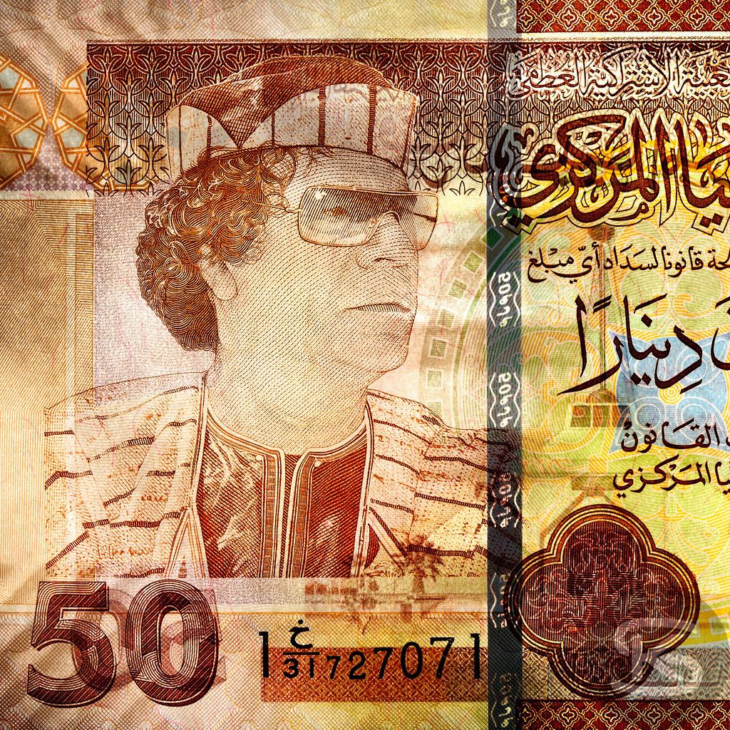 LIBYEN - Muammar al-Gaddafi | Staatsoberhaupt von Libyen und Diktator, 1942-2012 | Entdecken Sie "Gesichter der Währungen" – eine einzigartige Fotoserie von Stefan Kuhn, die Banknoten aus aller Welt als Kunstwerke neu interpretiert. Vorder- und Rückseite verschmelzen zu faszinierenden Kompositionen.  - Realisiert mit Pictrs.com