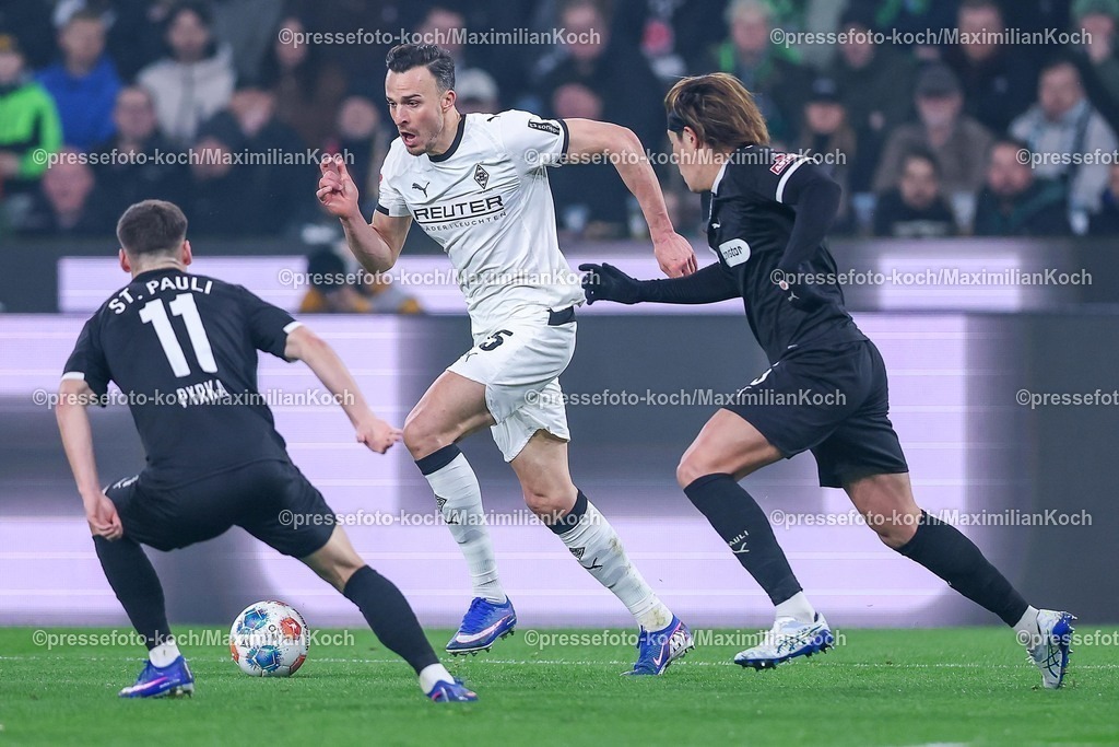 BMG13032601023 | 13.03.2026, Fußball, Borussia Mönchengladbach - FC St. Pauli, 1. Fußball Bundesliga, 26.Spieltag, Borussia-Park, Saison 2025 2026: Haris Tabakovic&nbsp;(Borussia Mönchengladbach #15) im Zweikampf gegen  Arkadiusz Pyrka&nbsp;(FC St.Pauli #11) Tomoya Ando (FC St. Pauli #15)  DFB regulations prohibit any use of photographs as image sequences and or quasi-video.