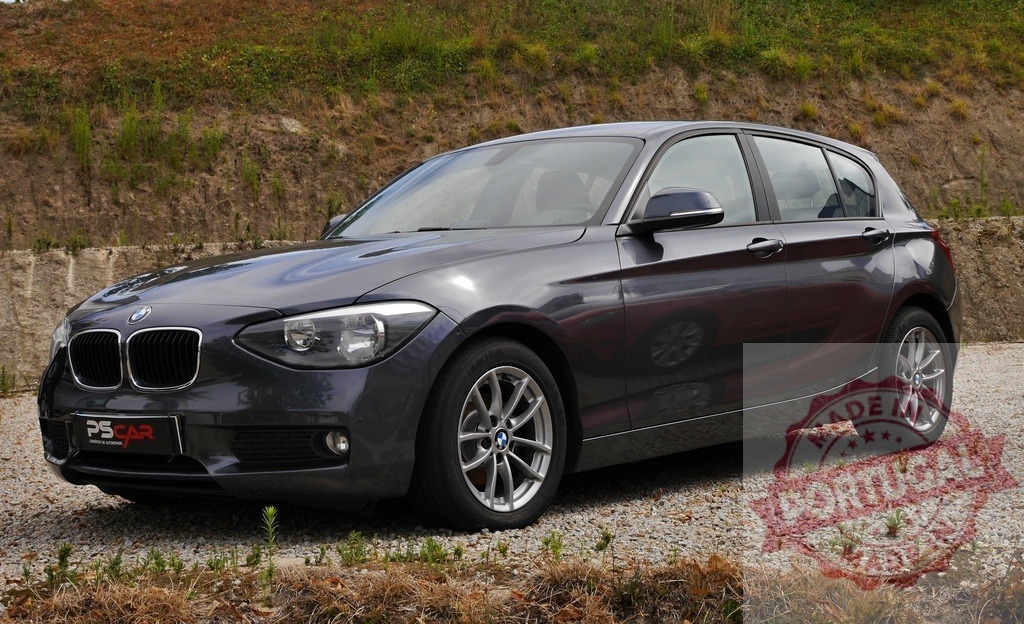 Grey BMW 1 Series hatchback parked outdoors | Grey BMW 1 Series car parked on gravel, showcasing modern design and transportation - Realized with Pictrs.com