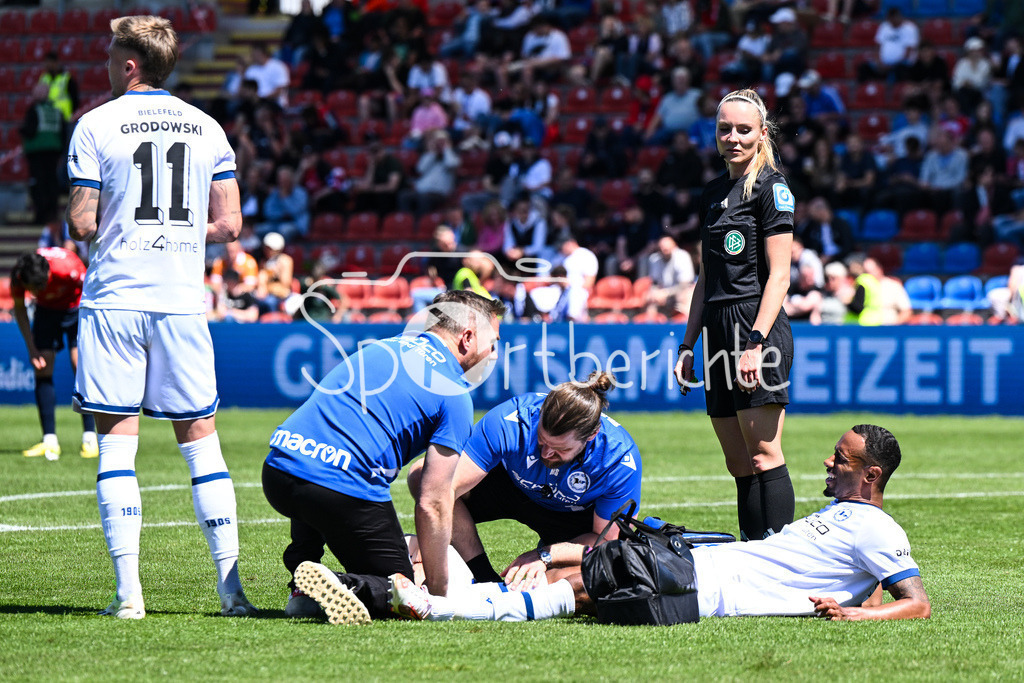 SpVgg Unterhaching - Arminia Bielefeld | der angeschlagene Noah Joel SARENREN BAZEE (Arminia Bielefeld 37) muss behandelt werden / Schiedsrichterin Fabienne MICHEL in Aktion / 3. Liga: SpVgg Unterhaching - Arminia Bielefeld, Uhlsport Park am 11.05.2025