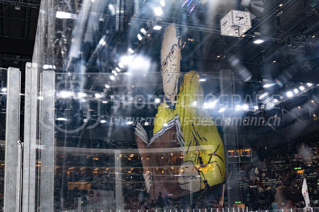 Playoffs: ZSC Lions - EHC Biel-Bienne | 27.03.2022, Zürich, Hallenstadion, Playoffs: ZSC Lions - EHC Biel-Bienne, die übergrosse Darstellung von Walter J. Scheibli spiegelt sich im Plexiglas des Hallenstadions. - Realisiert mit Pictrs.com