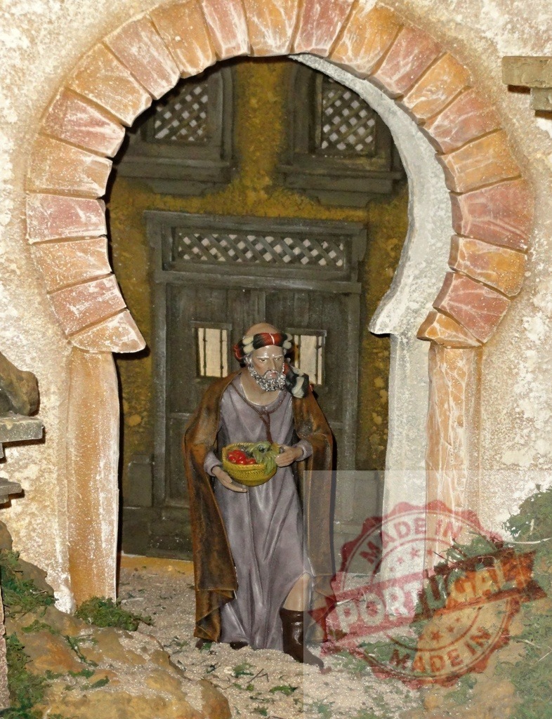 Wise man carrying gifts walking through stone arch in nativity scene | Figurine of a wise man carrying gifts walking through a stone arch in a traditional nativity scene, representing the journey to Bethlehem - Realisiert mit Pictrs.com