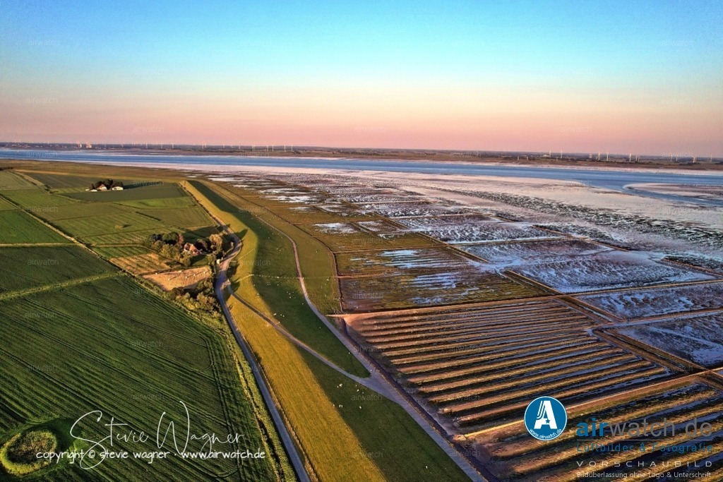 Luftbild Nordstrand, LangerDeich, Dreisprung, An de Wehl, Evensbüller Chaussee, Husumer Bucht | Luftbild Nordstrand, LangerDeich, Dreisprung, An de Wehl, Evensbüller Chaussee, Husumer Bucht - Die Landgewinnung auf Nordstrand ist Teil einer langen Tradition des Deichbaus und der Rekultivierung von Wattflächen. Bereits im Mittelalter begannen die Bewohner, Deiche zu errichten, um sich vor Sturmfluten zu schützen und neues Ackerland zu gewinnen. Im Laufe der Jahrhunderte wurden große Teile des Wattenmeers eingedeicht, wodurch die Halbinsel kontinuierlich vergrößert wurde.