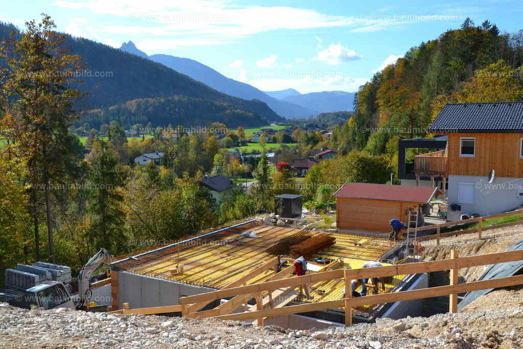 Kellerbau | Betonkeller in Hanglage, dahinter Berglandschaft mit blauem Himmel und Wolken 