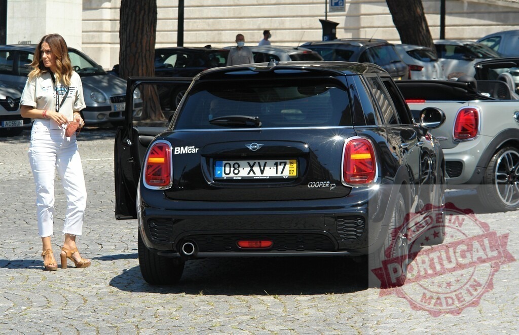 Woman getting into a black Mini Cooper D parked on a cobblestone street | Woman getting into a parked black Mini Cooper D on a cobblestone street in Lisbon, Portugal - Realisiert mit Pictrs.com