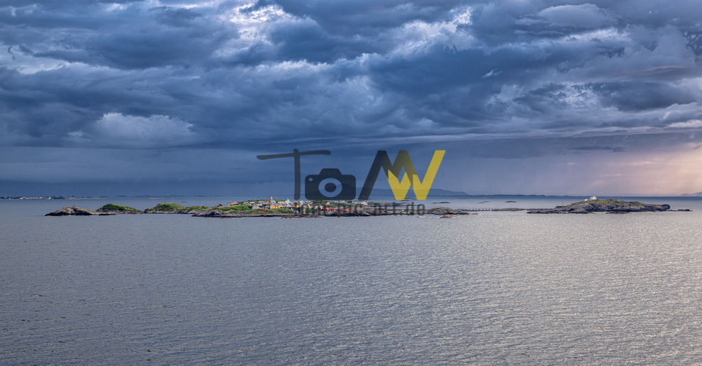 Blick auf eine Inselgruppe im Fjord von Molde-----Norwegen | Das Bild zeigt die Inselgruppe Værlandet in Norwegen, aufgenommen bei bewölktem Wetter. Værlandet liegt in der Gemeinde Askvoll in der Provinz Vestland.Die Inselgruppe ist durch Brücken und Dämme verbunden und Teil der Küstenstraße (Kystriksveien).Die Gegend ist bekannt für ihre raue Natur, Felsformationen und zahlreiche kleine Schäreninseln. - Realisiert mit Pictrs.com