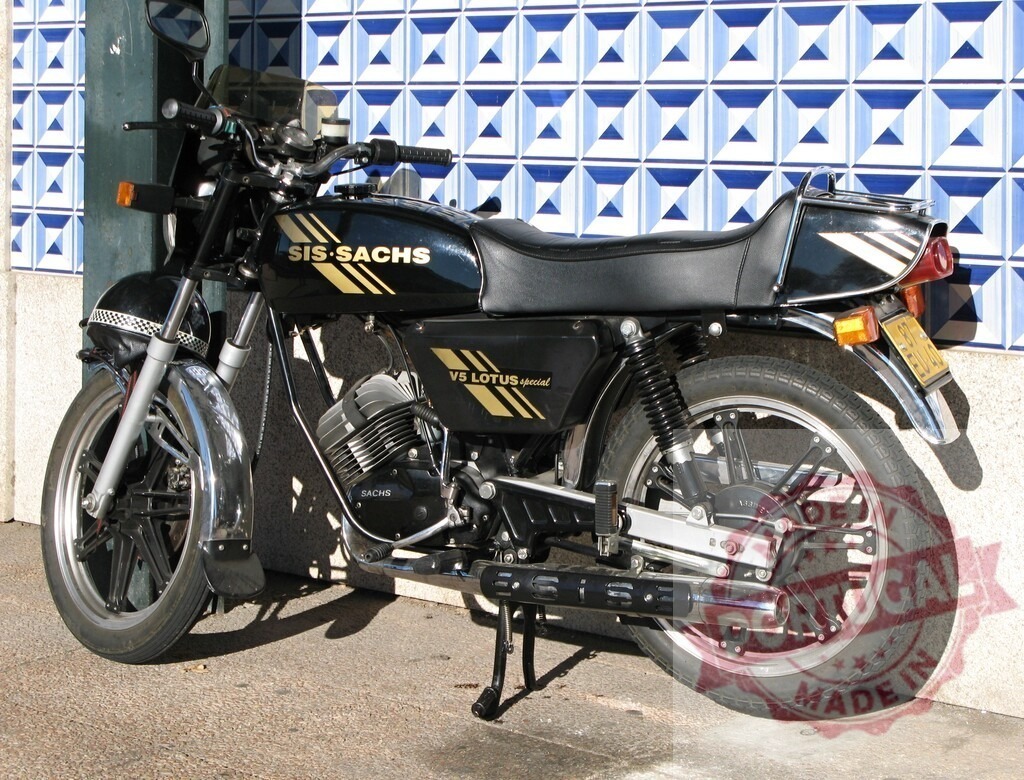 Black SIS-Sachs V5 Lotus Special Motorcycle Parked near a Tiled Wall | Classic SIS-Sachs V5 Lotus Special motorcycle parked near a wall featuring blue and white geometric tiles - Realisiert mit Pictrs.com