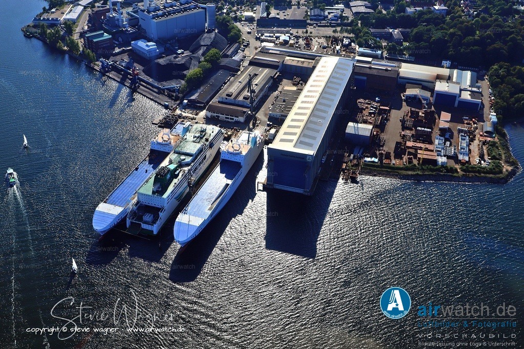 Luftbild Flensburger Schiffbau Gesellschaft FSG - Die Werft wurde mehrfach Ziel schwerer Bombenangriffe | Während des Zweiten Weltkrieges wurde die Flensburger Werft (Flensburger Schiffbau Gesellschaft) als bedeutender Produktionsstandort für U-Boote genutzt, insbesondere für die Klasse VII des Typs VII C. Die Werft war ein zentrales Ziel für Luftangriffe der Alliierten, da sie eine Schlüsselrolle bei der U-Boot-Produktion spielte. Die Werft wurde mehrfach Ziel schwerer Bombenangriffe, wobei die Angriffe vor allem ab 1942 zunahmen, nachdem die Alliierten die Lufthoheit über Deutschland erlangten.