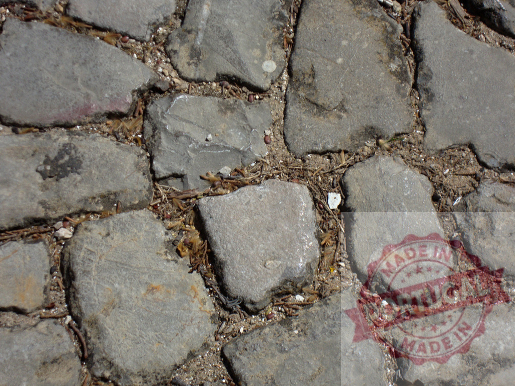 Cobblestone pavement creating a textured surface with dirt and debris | Close-up view of a cobblestone pavement showing the rough texture of the stones, dirt, and debris filling the gaps - Realized with Pictrs.com