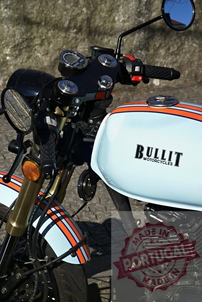 Bullit Motorcycle Parked on Cobblestone Street | Close-up of a Bullit motorcycle showcasing its design and branding - Realisiert mit Pictrs.com