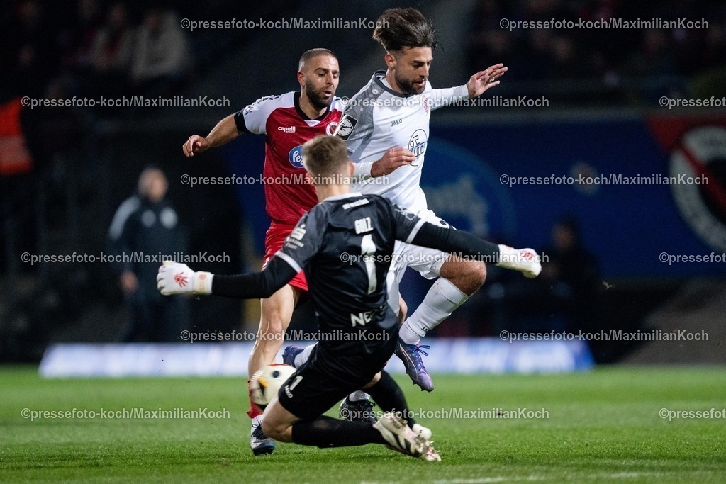 xYDR12032501078 | 12.03.2025, xydrx, Fußball, Viktoria Köln - Rot-Weiss Essen, 3.Liga, Sportpark Höhenberg, Saison 2024 2025:  Serhat-Semih Güler (Viktoria Köln #30) im Zweikampf gegen Jose-Enrique Rios Alonso (Rot-Weiss Essen #23) und Jakob Golz (Rot-Weiss Essen #1). DFB regulations prohibit any use of photographs as image sequences and or quasi-video.