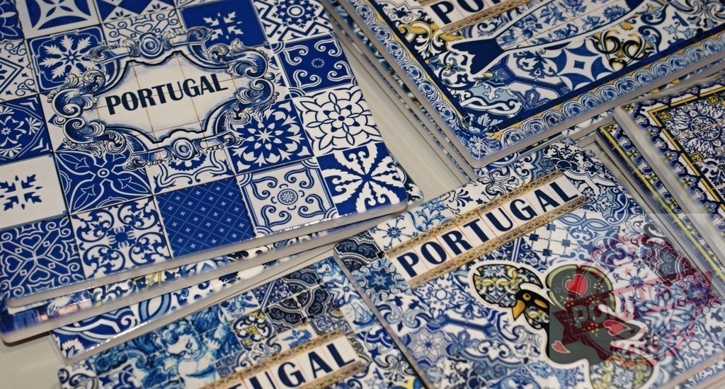 Portugal azulejo tile souvenirs with rooster Barcelos design | Portuguese azulejo souvenirs featuring blue tile patterns and a Rooster of Barcelos decorate a surface - Realized with Pictrs.com
